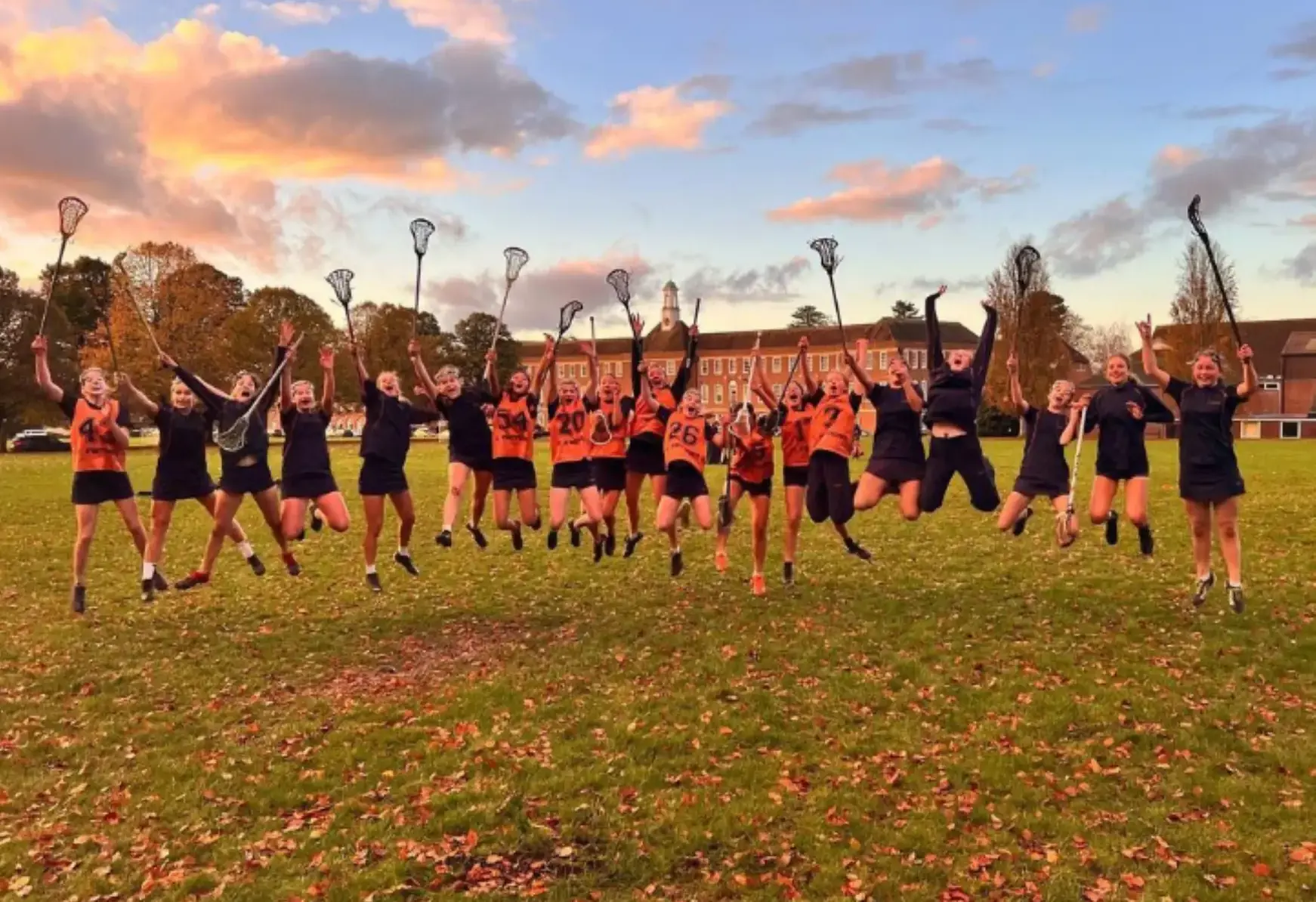 Lacrosse players jumping and raising their arms