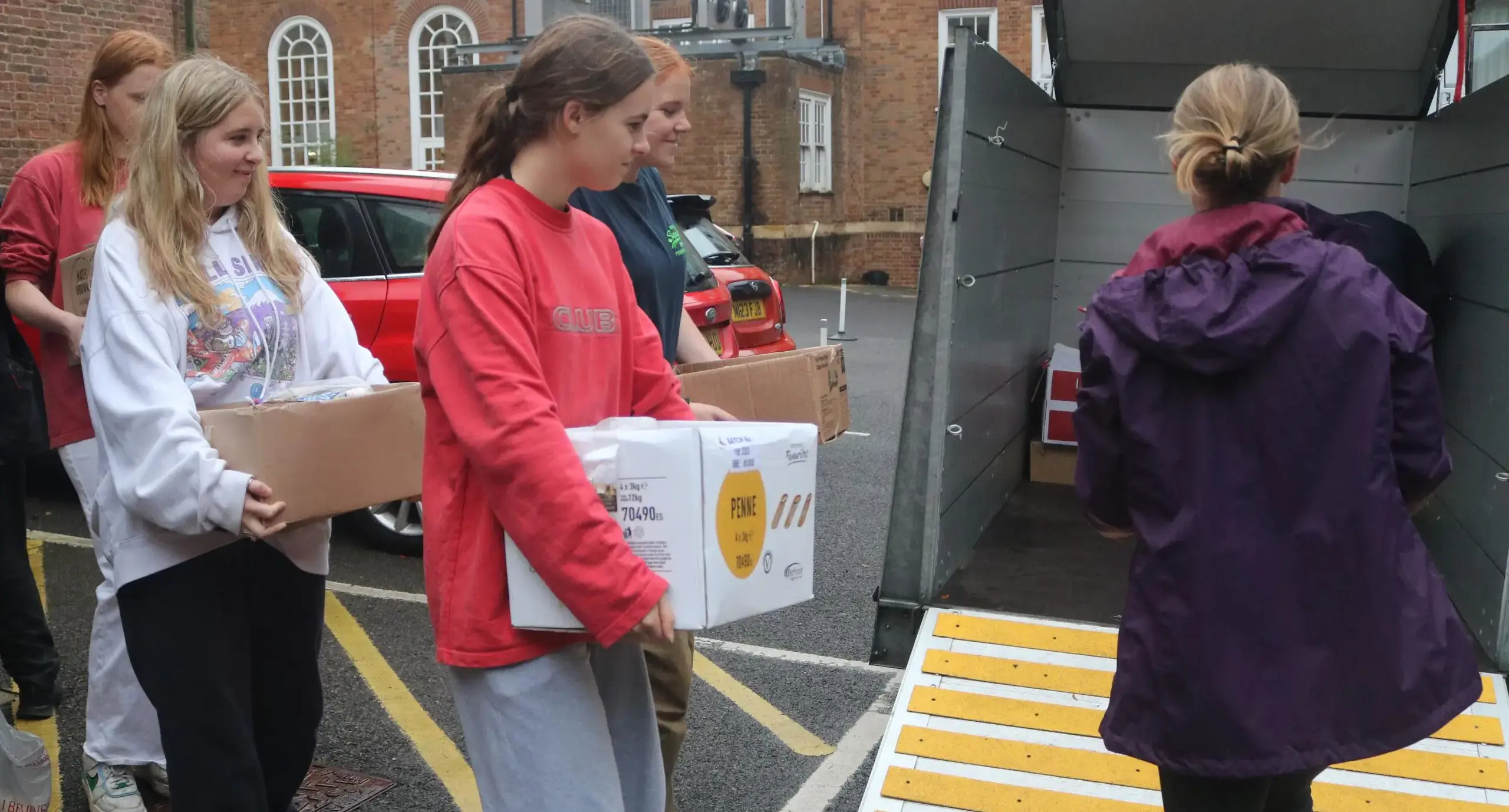 Students loading boxes into a van