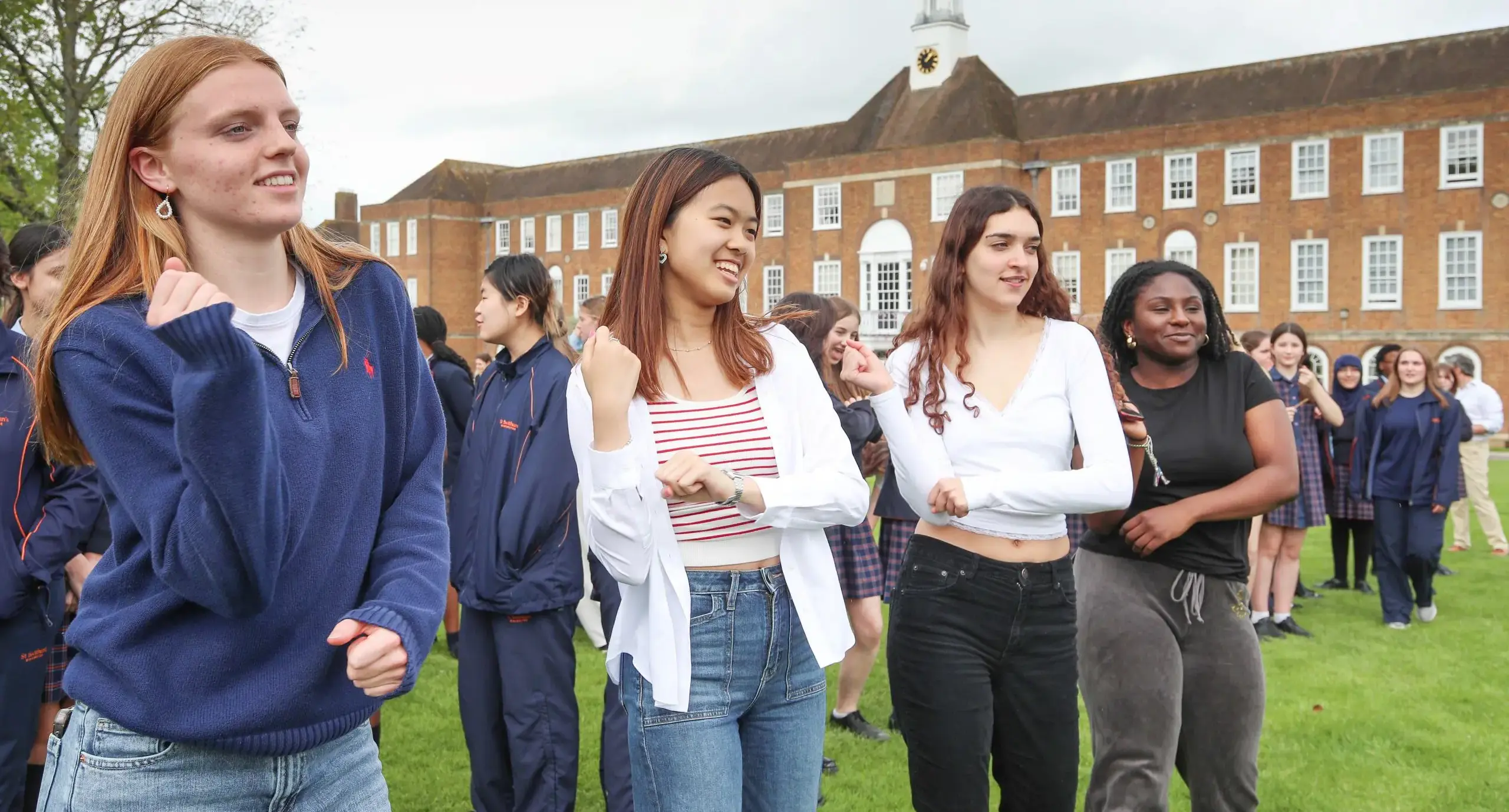 Sixth formers dancing in front of the main school building at St Swithun’s independent boarding and day school for girls