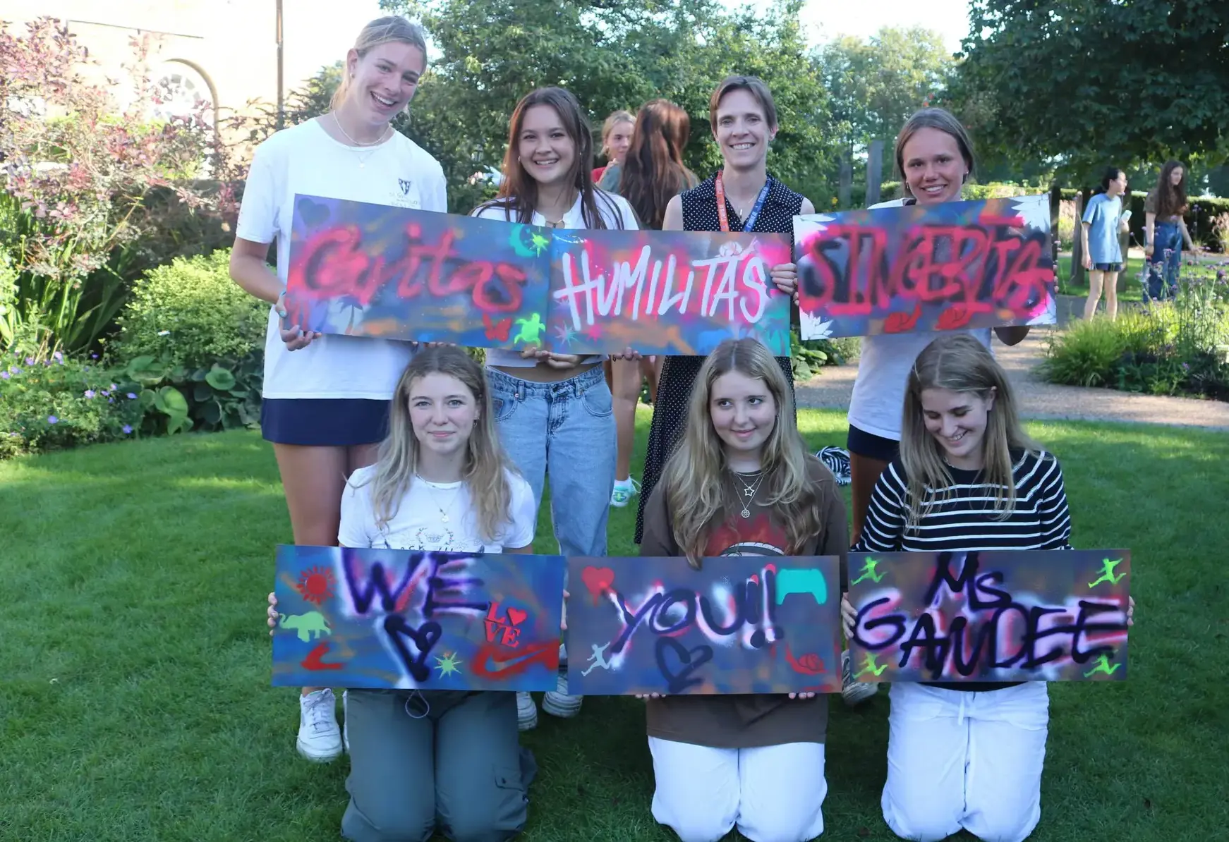 Sixth formers holding up grafitti art on St Swithun's values