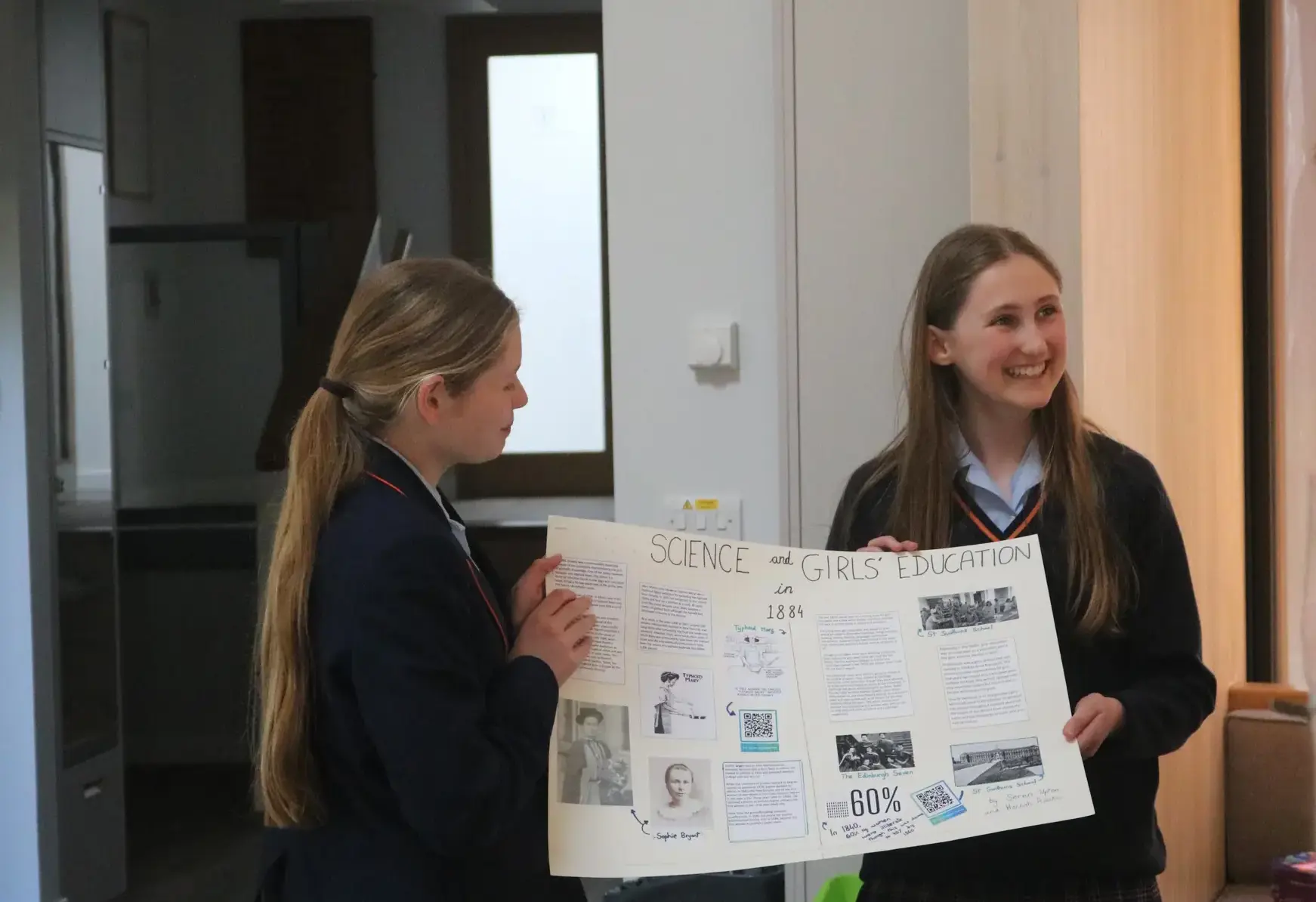 Two girls presenting a project poster