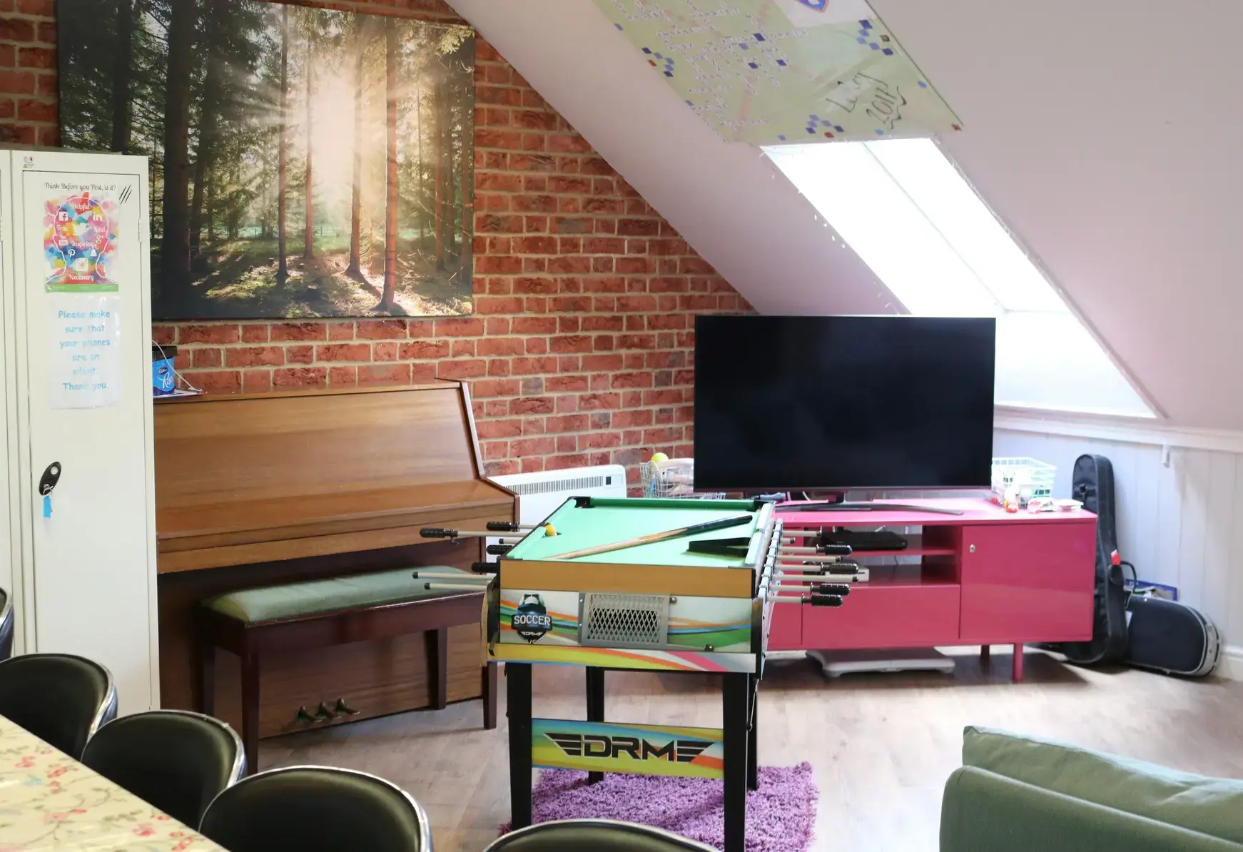 Recreation room in boarding school, featuring foosball table and television