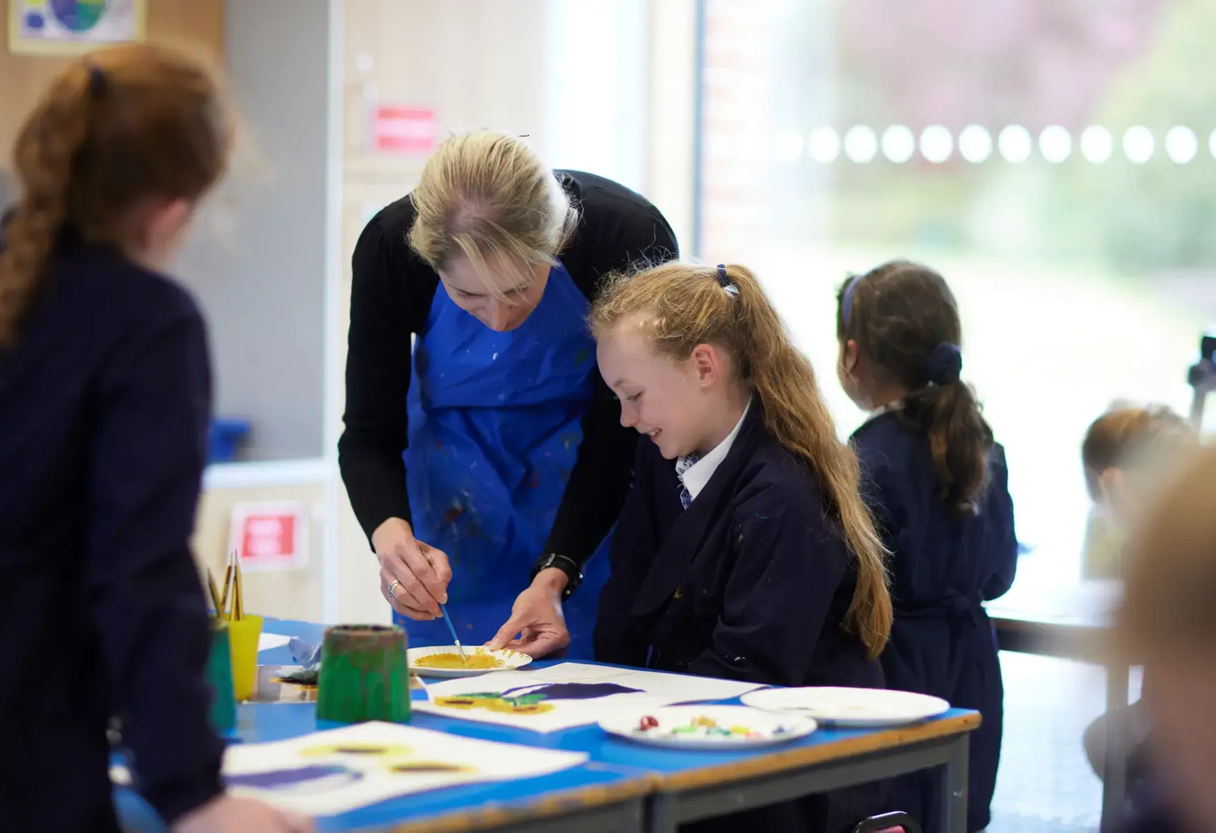 Teacher helping student with painting