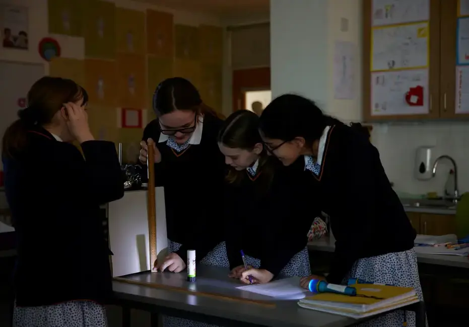 Students measuring items in a science lesson