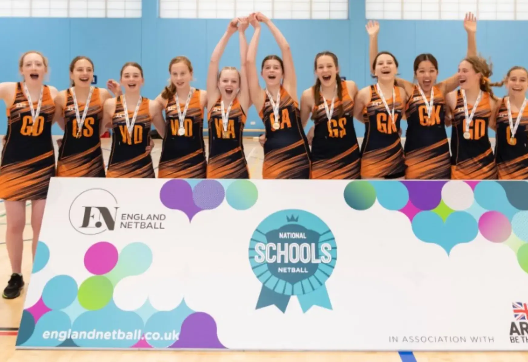 Student athletes, possibly netball players, celebrating a win