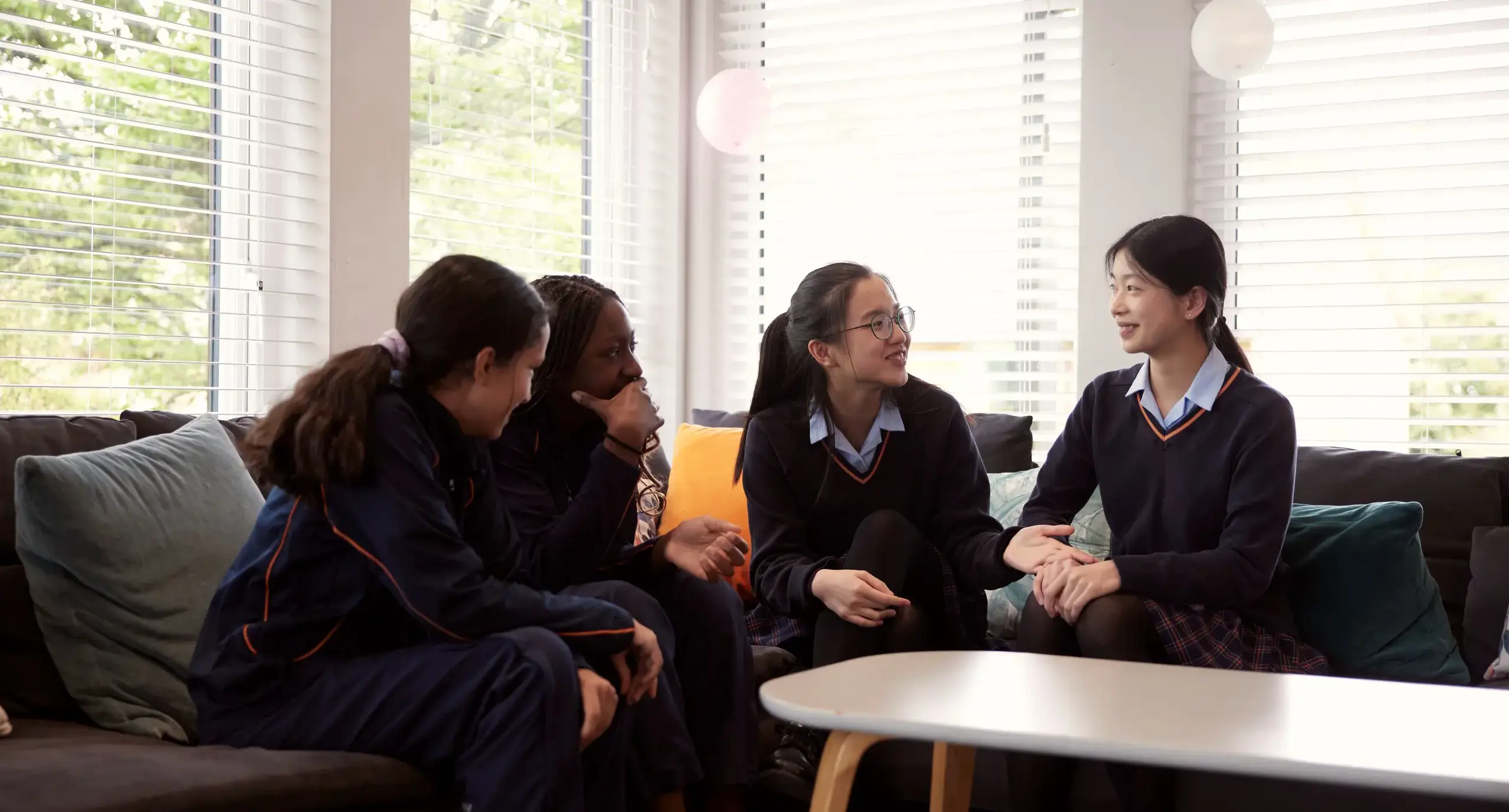 Boarding pupils laughing on sofa