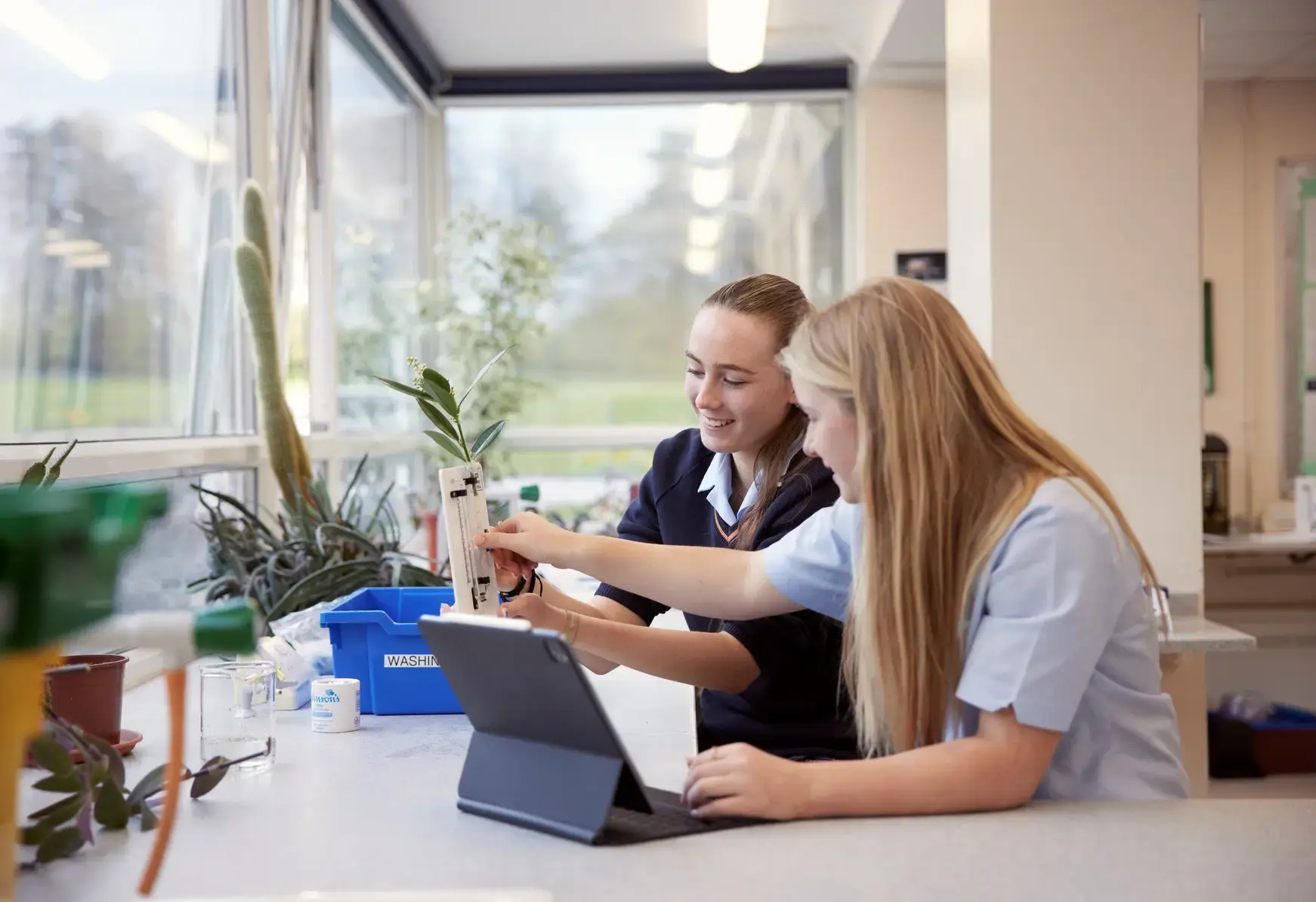 Two students collaborating in front of a tablet