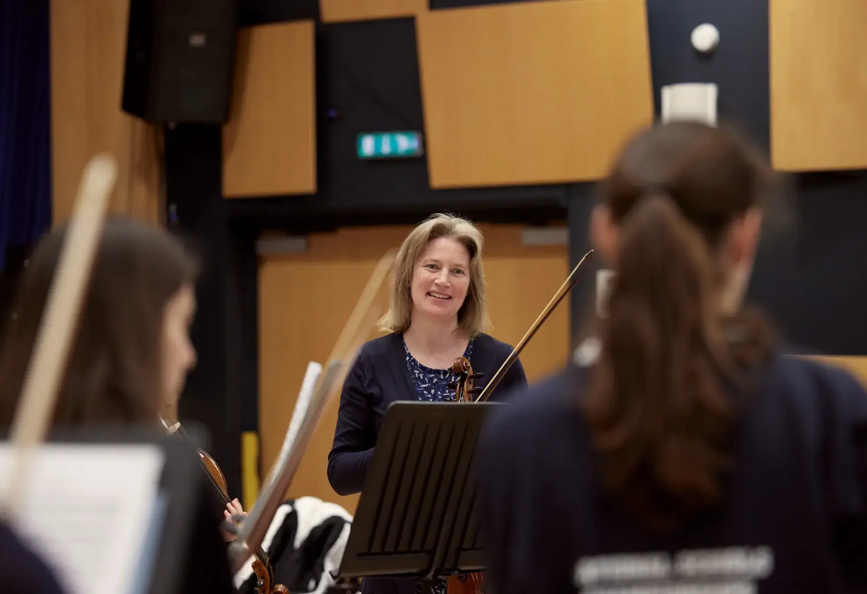 Teacher presiding over student orchestra