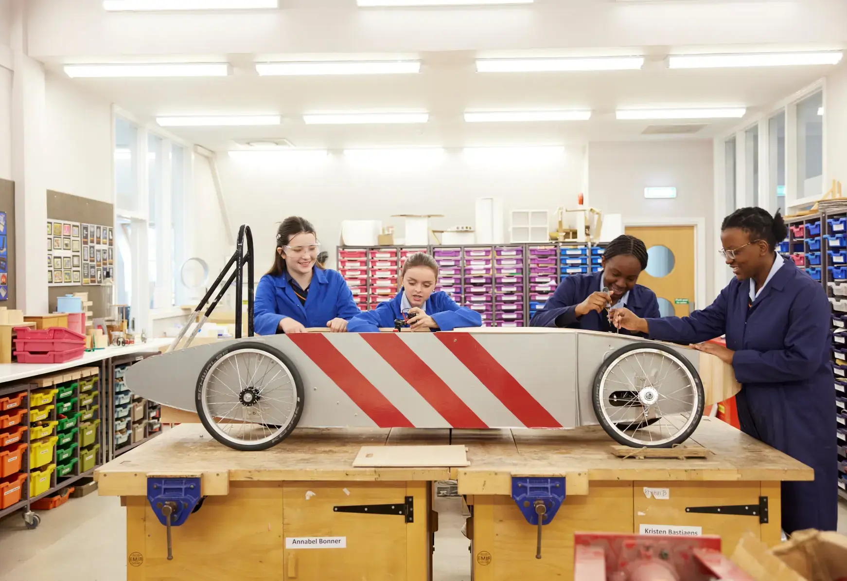 Students working on a car in woodwork lessons