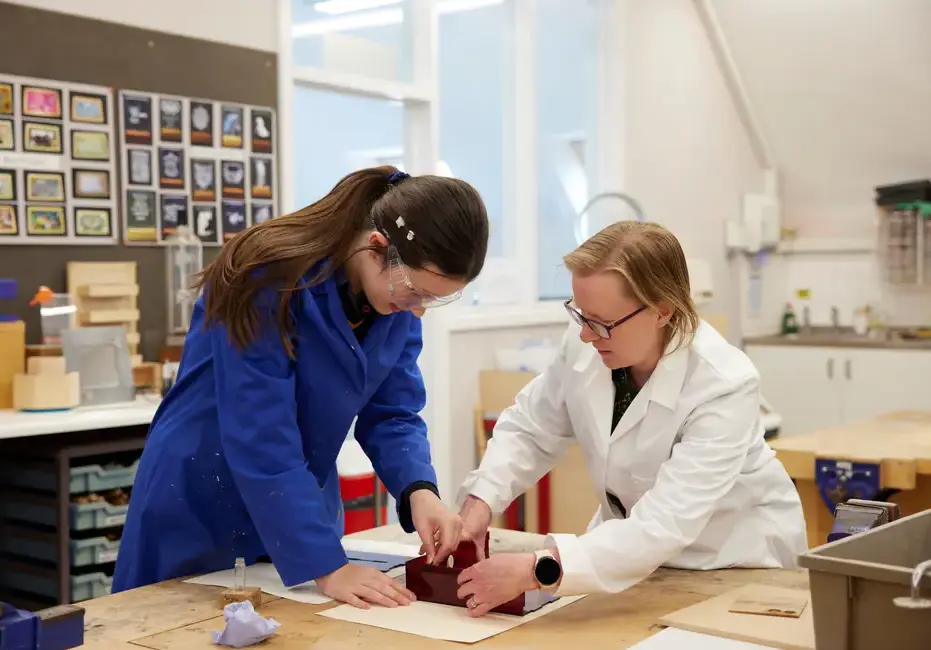 A teacher in a science lesson assisting a student