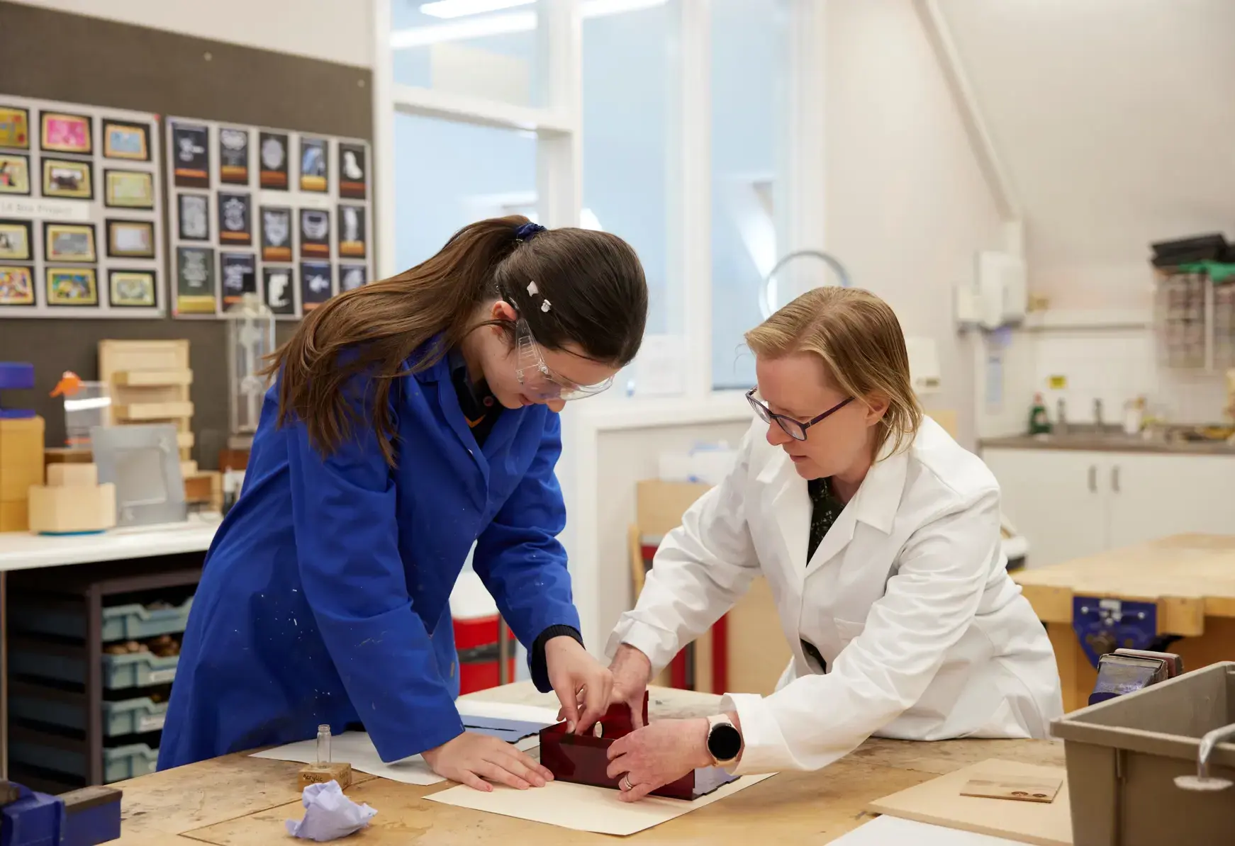 Science teacher helping student in lab