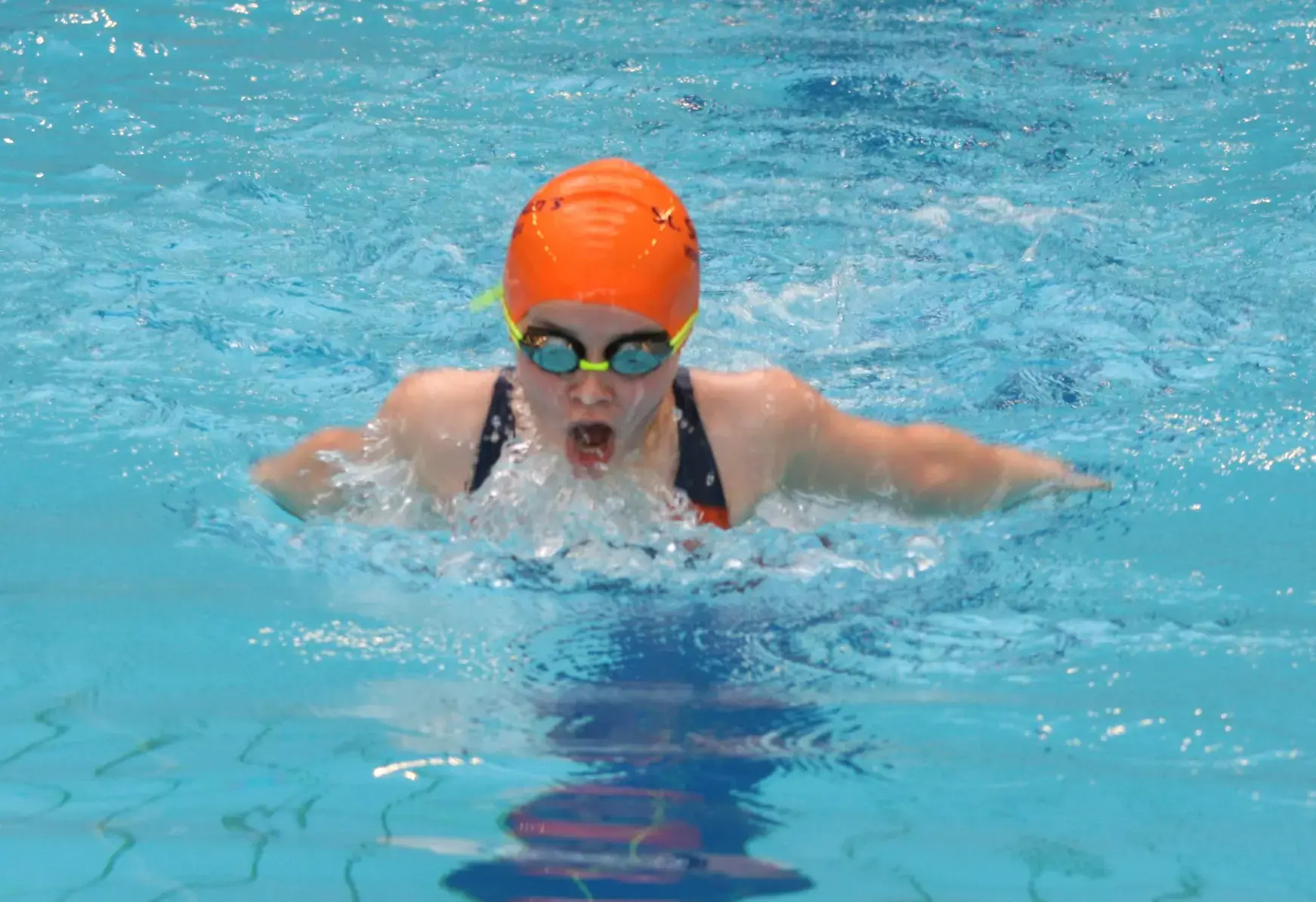 Student swimming in indoor pool