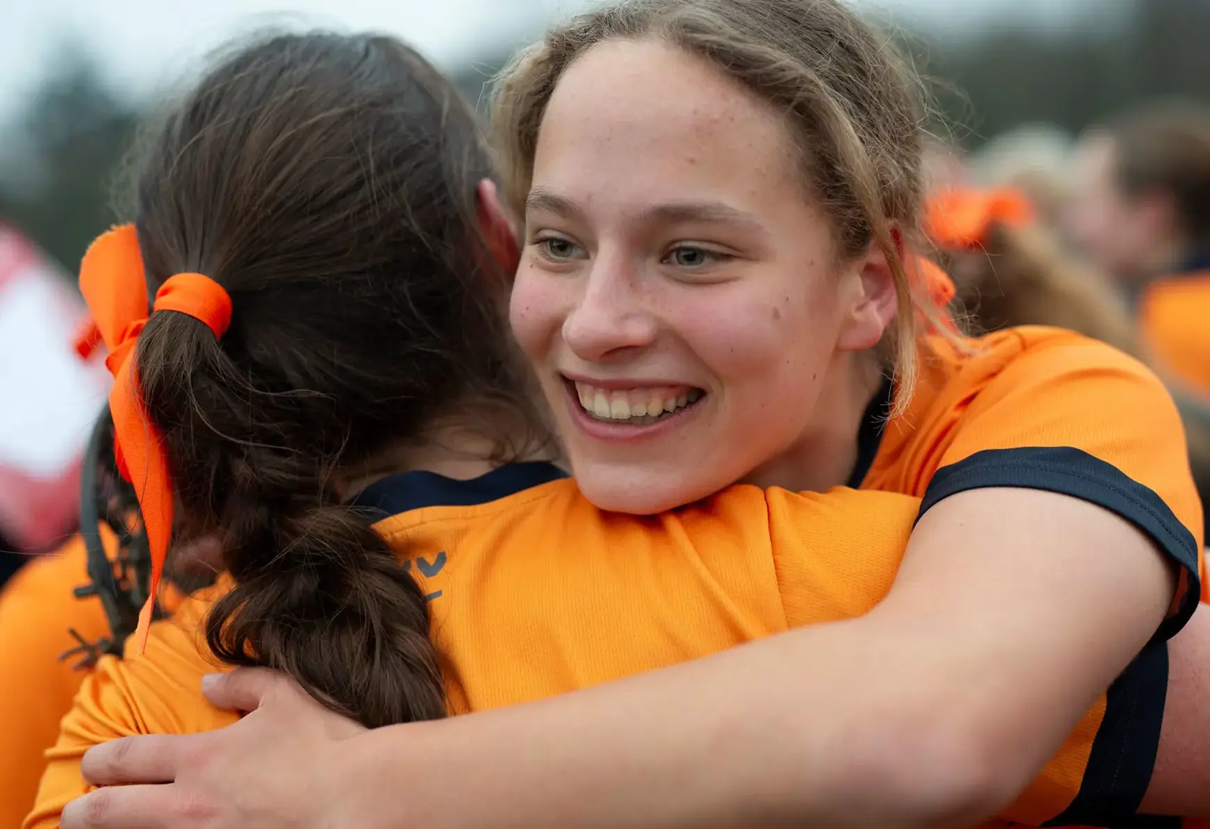 Two student athletes embracing